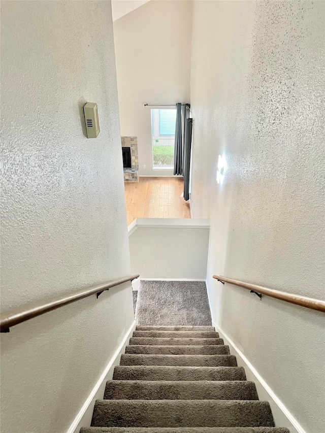 7854 Green Lawn Dr Unit 7854, Houston, TX 77088 - stairs with a textured wall and a stone fireplace