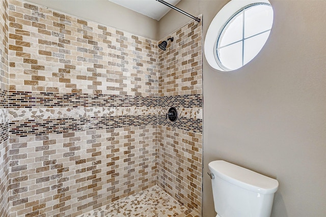 bathroom with toilet and tiled shower