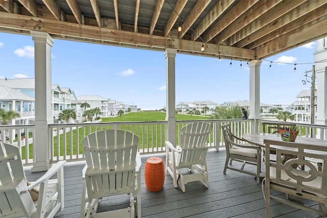 deck with a yard, outdoor dining area, and a residential view