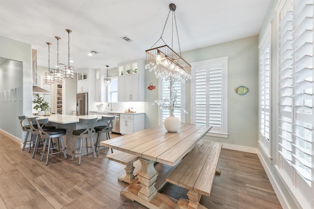 dining area with visible vents, baseboards, and wood finished floors