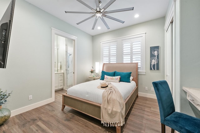 bedroom with connected bathroom, ceiling fan, and dark hardwood / wood-style flooring