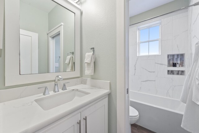 full bathroom featuring vanity, toilet, and tiled shower / bath