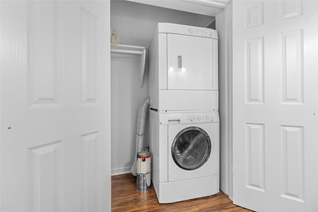 washroom featuring stacked washer / dryer and dark wood-type flooring