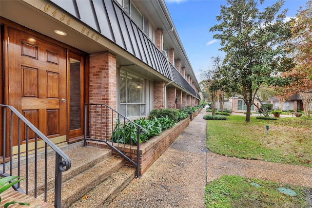 view of exterior entry featuring a yard