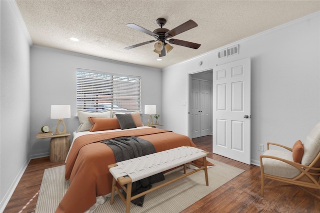 bedroom featuring dark hardwood / wood-style flooring, a textured ceiling, ceiling fan, and ornamental molding