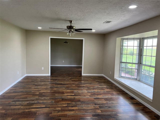 empty room with a textured ceiling, dark hardwood / wood-style flooring, and ceiling fan