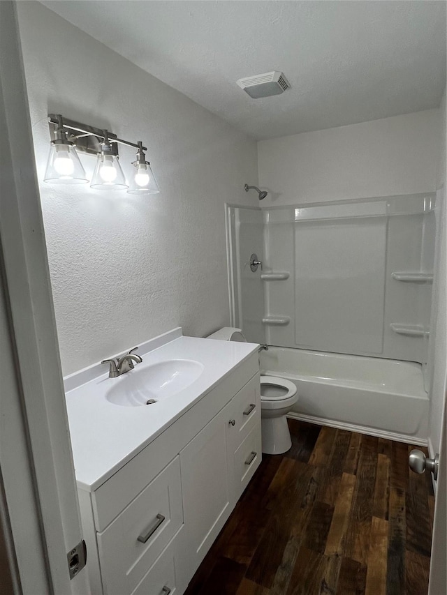 full bathroom featuring hardwood / wood-style floors, vanity,  shower combination, and toilet