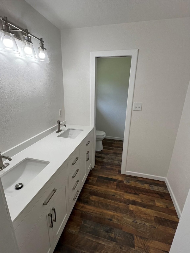 bathroom with hardwood / wood-style floors, vanity, and toilet