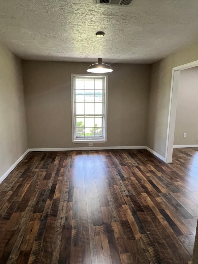 unfurnished room featuring a textured ceiling and dark wood-type flooring