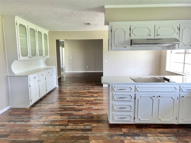 kitchen featuring white cabinets, dark hardwood / wood-style flooring, black electric cooktop, and a textured ceiling