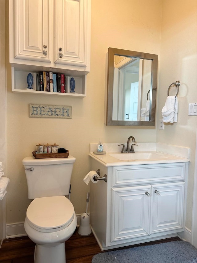 bathroom featuring vanity, wood-type flooring, and toilet