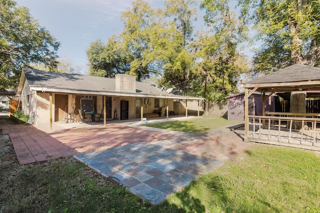 rear view of property with a yard and a patio