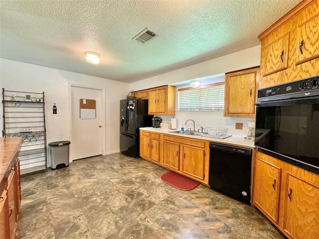 kitchen featuring sink, black appliances, and a textured ceiling