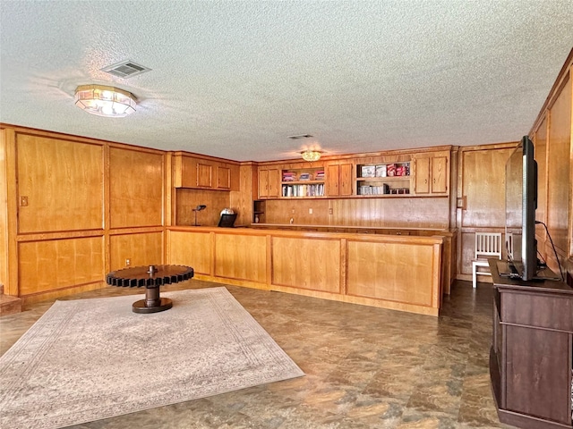 kitchen with wood walls and a textured ceiling