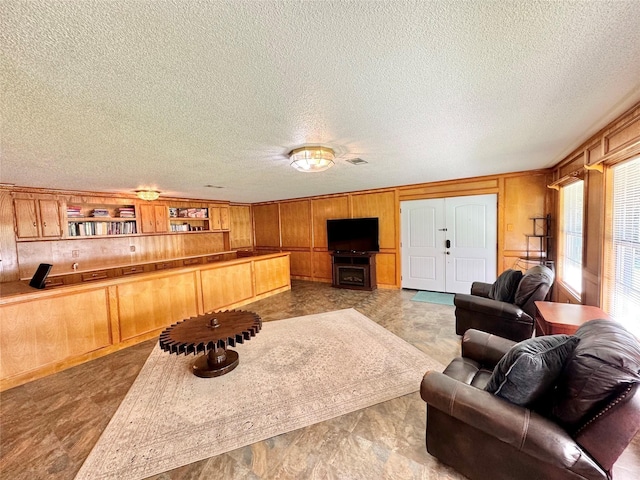 living room with wood walls and a textured ceiling