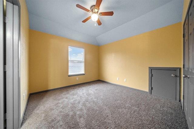 empty room featuring ceiling fan, lofted ceiling, and carpet floors