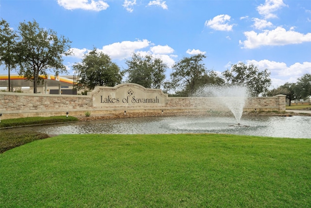 view of home's community with a lawn and a water view