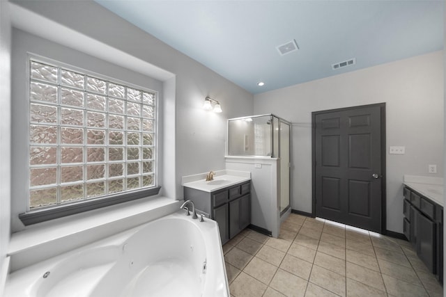 bathroom with a wealth of natural light, tile patterned flooring, and vanity