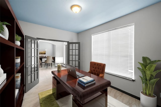 home office featuring french doors, light hardwood / wood-style floors, and plenty of natural light