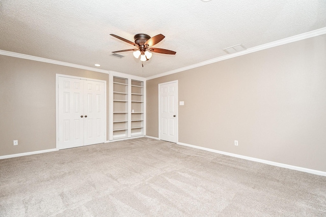 unfurnished bedroom with ceiling fan, crown molding, carpet floors, and a textured ceiling