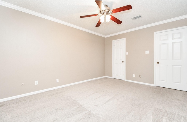 carpeted spare room with ceiling fan, ornamental molding, and a textured ceiling