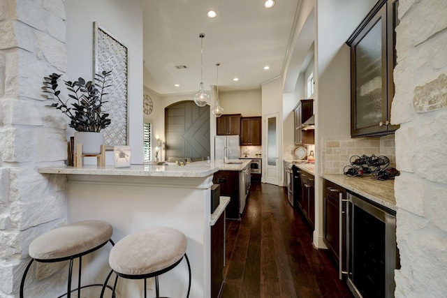 kitchen featuring a breakfast bar, light stone countertops, dark wood-type flooring, and wine cooler