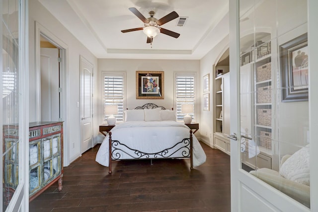 bedroom featuring ceiling fan, dark hardwood / wood-style flooring, and multiple windows