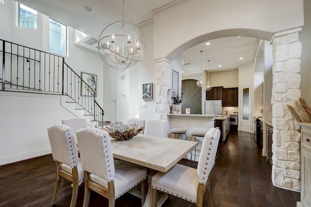 dining room with a notable chandelier, dark hardwood / wood-style flooring, crown molding, and decorative columns