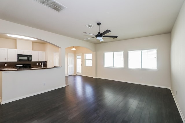 unfurnished living room with ceiling fan and dark hardwood / wood-style flooring