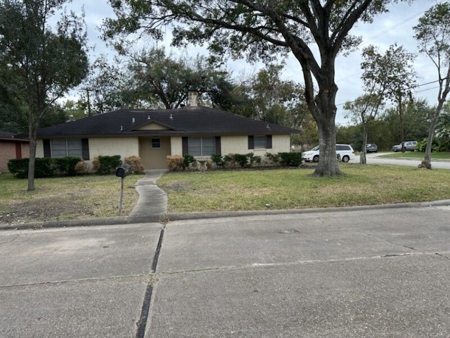 ranch-style home featuring a front lawn