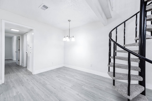 interior space featuring hardwood / wood-style floors, beamed ceiling, and an inviting chandelier