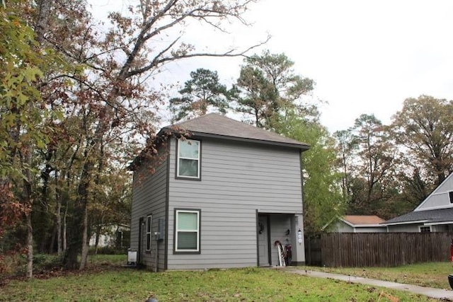 rear view of property featuring a lawn