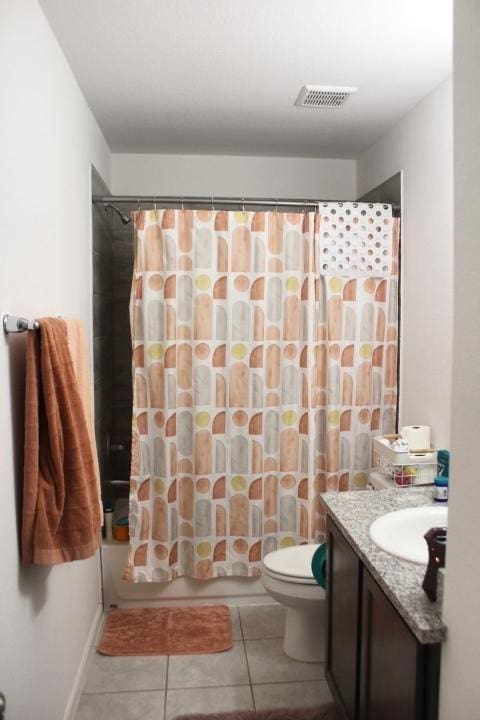 full bathroom featuring tile patterned floors, vanity, toilet, and shower / bathtub combination with curtain