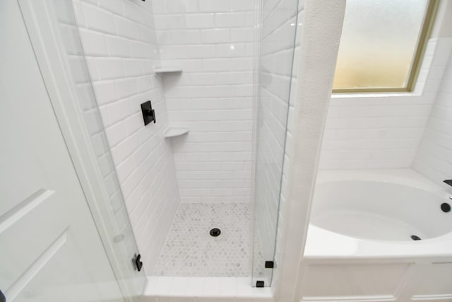 bathroom featuring shower with separate bathtub