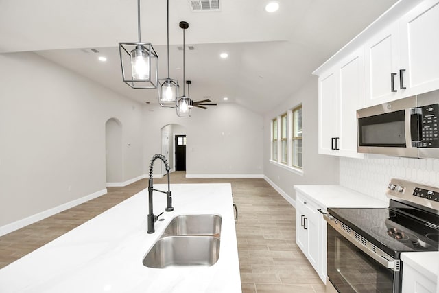 kitchen featuring sink, white cabinets, hanging light fixtures, and appliances with stainless steel finishes