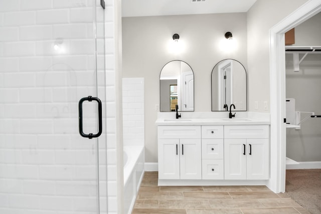 bathroom with vanity and shower with separate bathtub