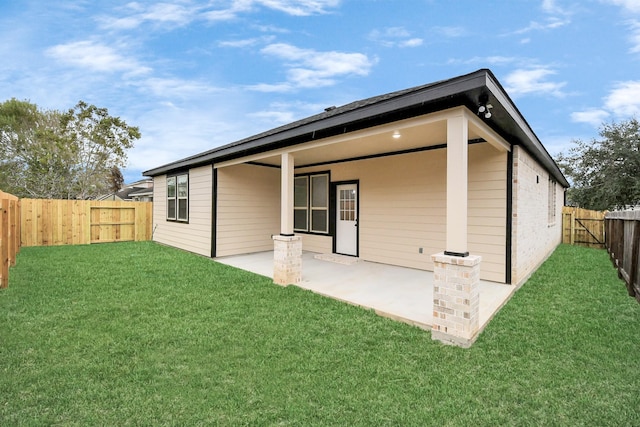 back of property featuring a patio area and a yard