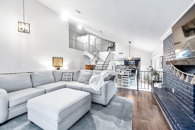 living room with a brick fireplace, dark hardwood / wood-style floors, high vaulted ceiling, and a wealth of natural light