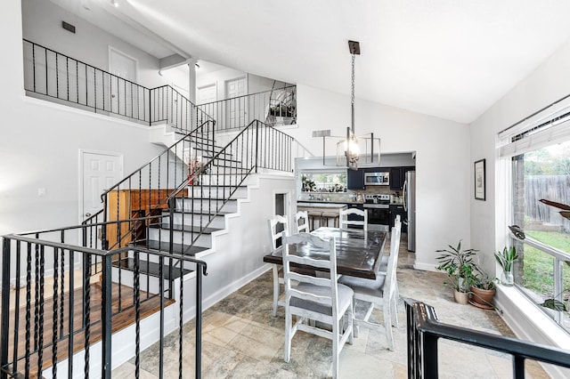 dining room with high vaulted ceiling