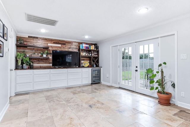 interior space featuring bar area, ornamental molding, beverage cooler, and french doors