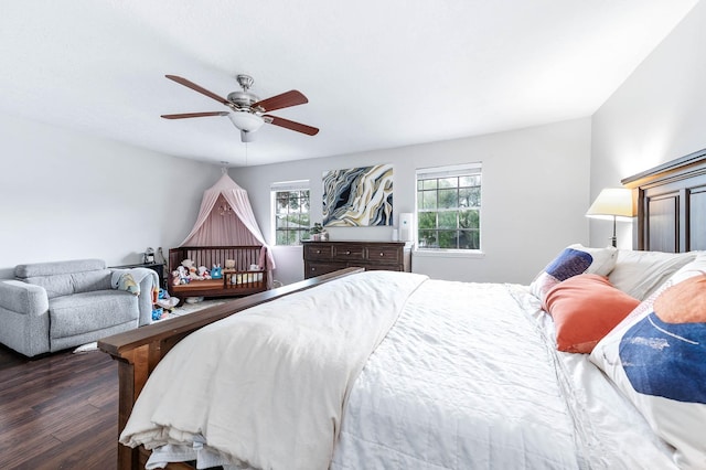 bedroom with ceiling fan, dark hardwood / wood-style flooring, and multiple windows