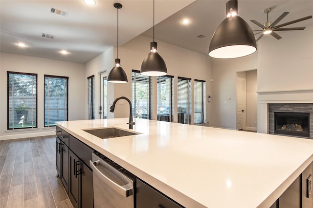 kitchen with sink, wood-type flooring, pendant lighting, a center island with sink, and dishwasher