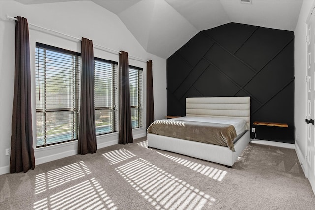 bedroom with carpet floors, vaulted ceiling, and multiple windows