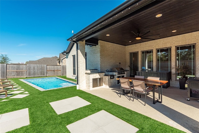 view of swimming pool with a grill, ceiling fan, exterior kitchen, and a patio