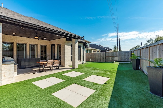 view of yard featuring ceiling fan and a patio