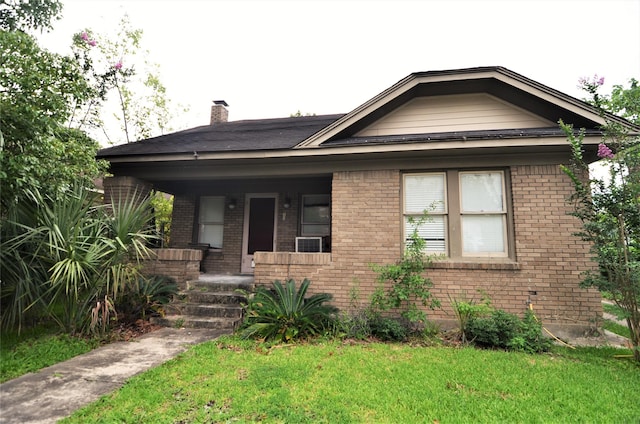 bungalow-style home with covered porch and a front lawn