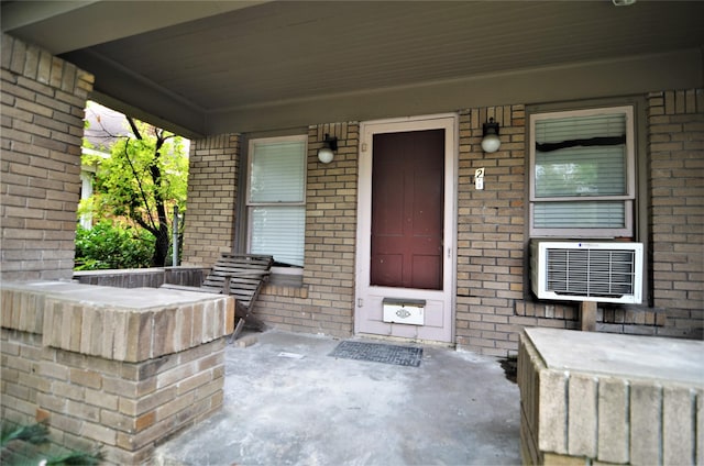 view of patio / terrace featuring a wall unit AC and a porch