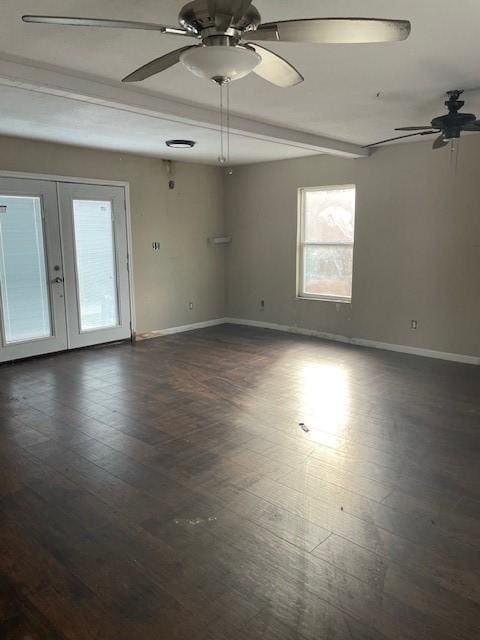 empty room featuring beamed ceiling, dark hardwood / wood-style floors, ceiling fan, and french doors