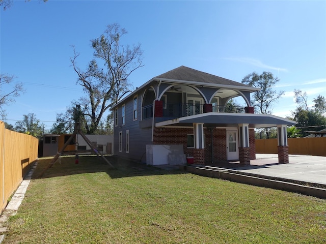 view of front facade with a front yard and a balcony