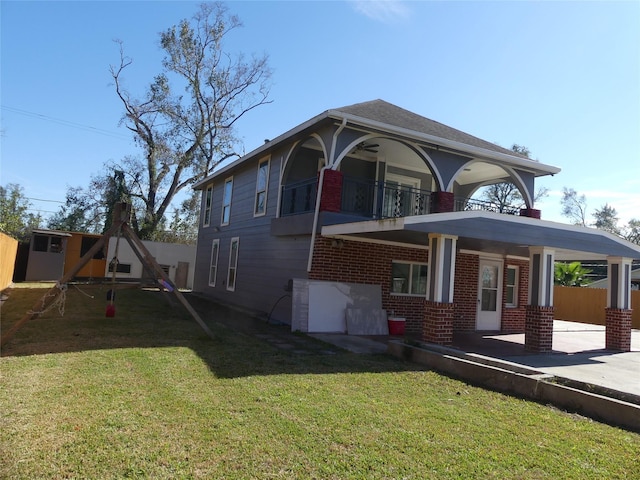 view of front of home with a balcony, covered porch, a front yard, and a storage shed